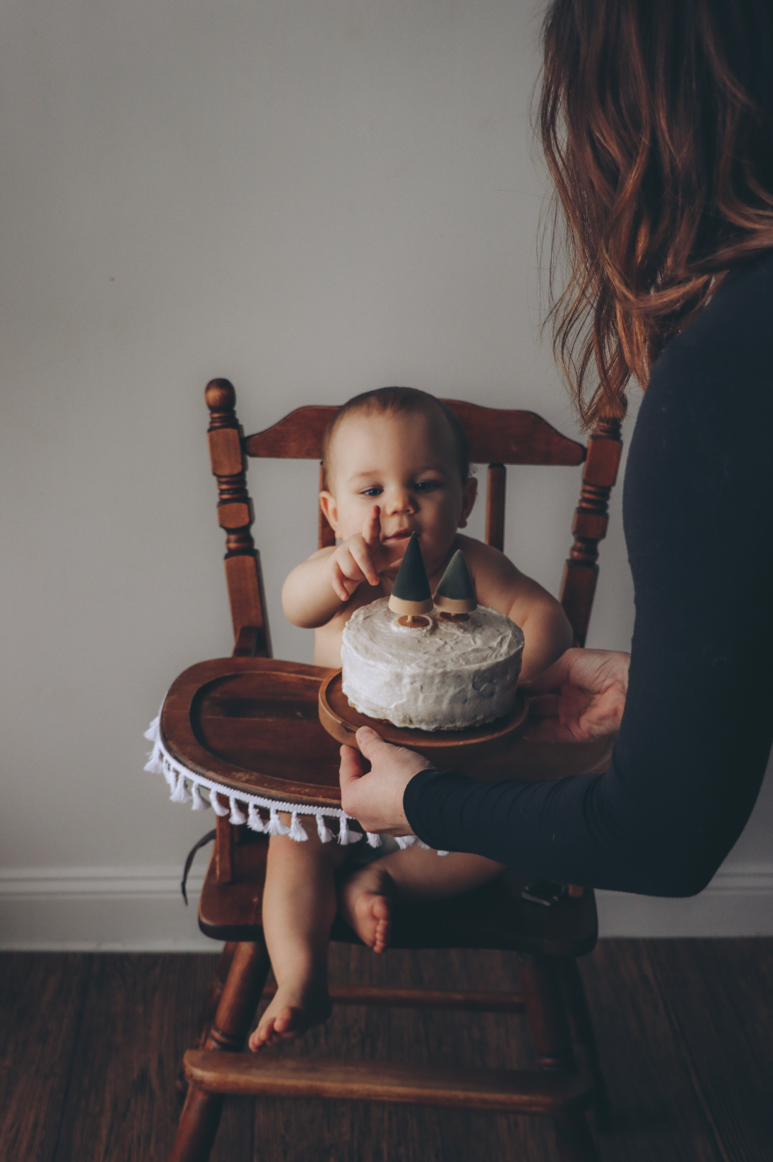 A happy baby being presented with a cake