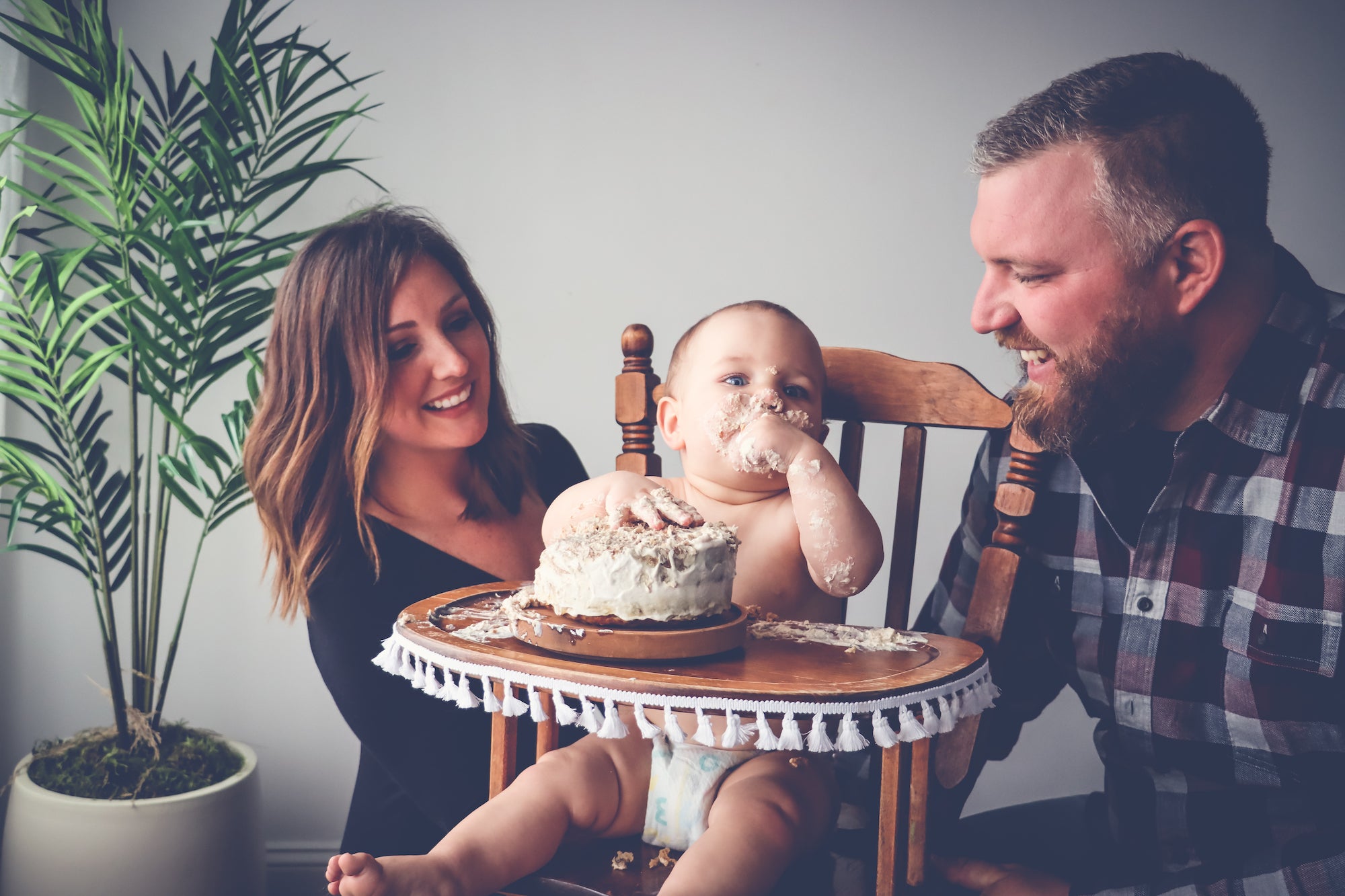 Ooby's Cake Smash Birthday Celebration a baby in a high chair enjoying birthday cake